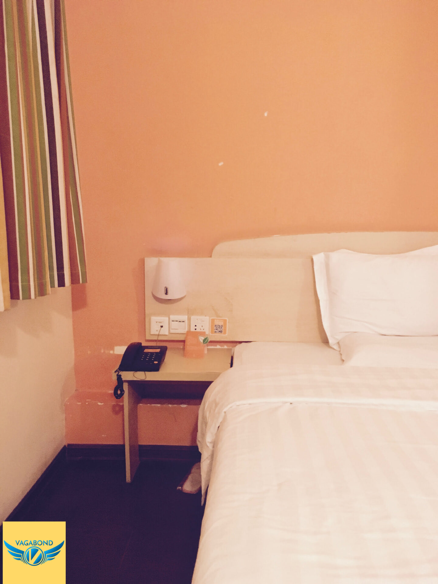 7天連鎖酒店(7 Days Inn)的床頭與窗戶。