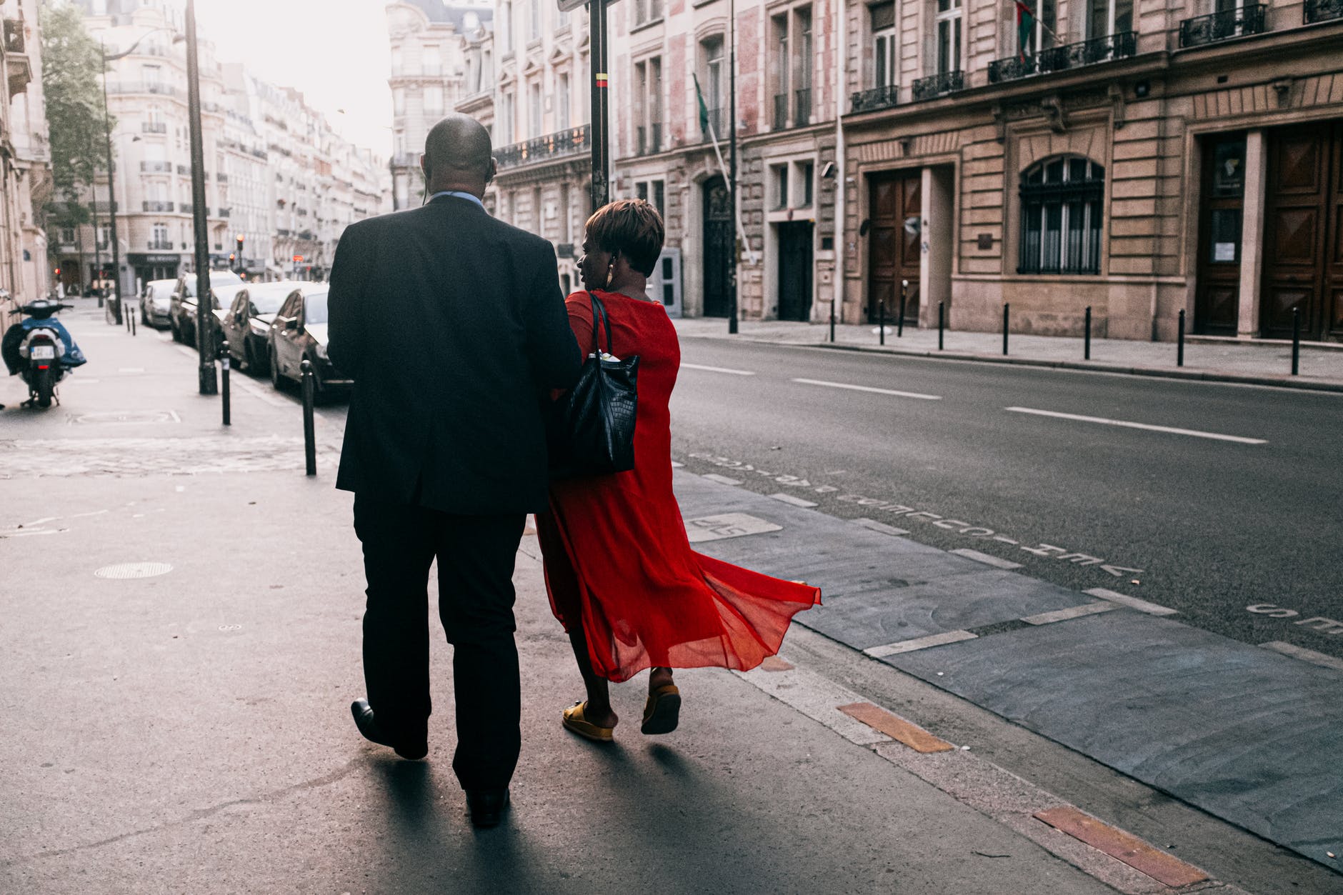 man and woman walking on sidewalk