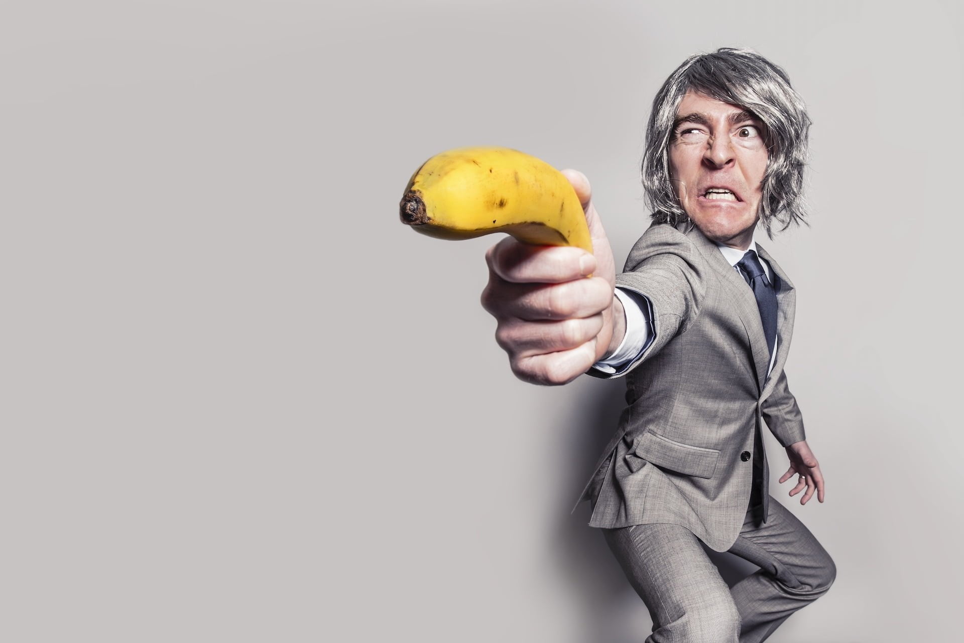 臉書 Facebook 陷阱 一張圖片讓粉絲團秒犯眾怒 小編都該注意的血淚教訓 man in gray suit jacket holding yellow banana fruit while making face