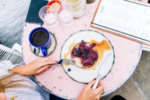 讚美食物美味的 26 個料理常用英文單字（寄宿家庭、朋友餐會必學） woman holding spoon and fork blackberries plate mug table Delicious