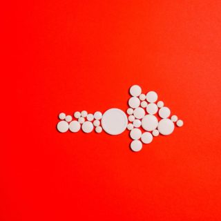 white round medication pill on red surface