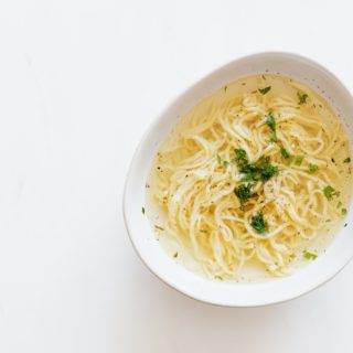 bowl with chicken noodle soup and parsley