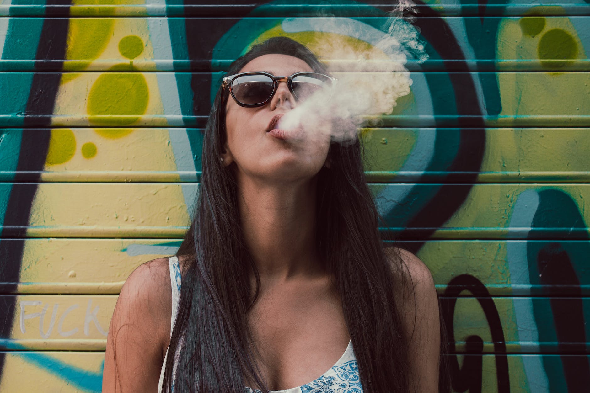 Woman wearing sunglasses while smoking
