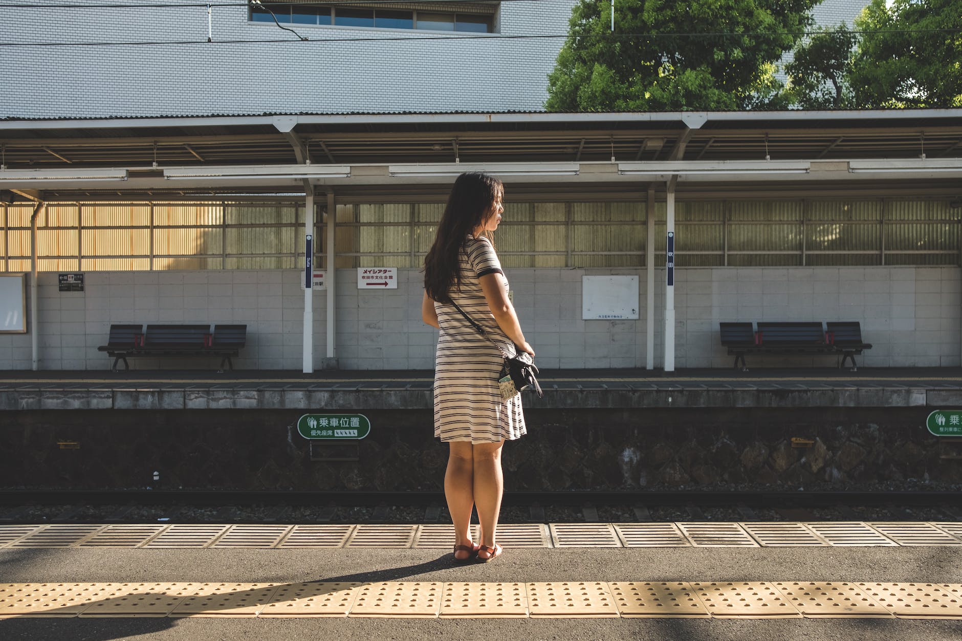 在日本鐵路月台上等待火車到來的女人
